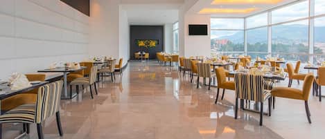 Un comedor amplio con mobiliario moderno y vistas a la ciudad.