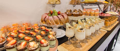 Un bufé con diversos postres y bebidas.