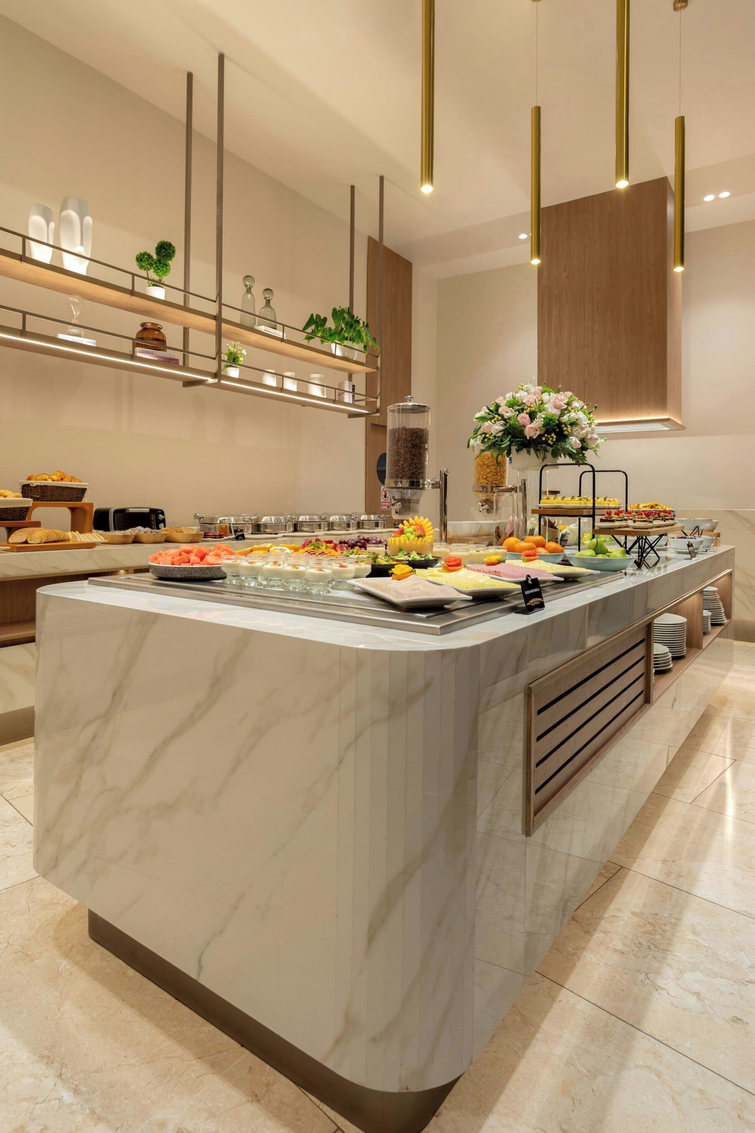 A modern kitchen with a marble island, stainless steel appliances, and a variety of food items.