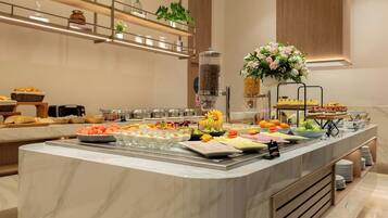 A modern kitchen with a marble island, stainless steel appliances, and a variety of food items.