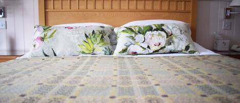 A bed with a floral-patterned pillow and a patterned bedspread.