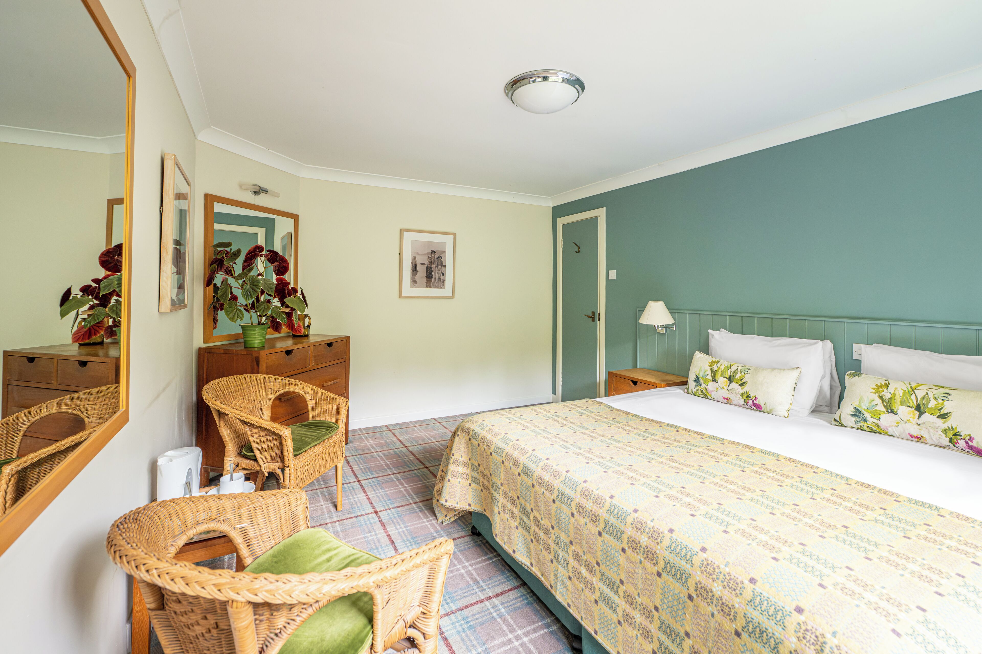 A bedroom with a bed, a dresser, a mirror, and a chair.