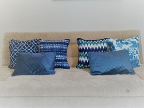 A beige sofa with six patterned cushions in various shades of blue. - Beautiful Apartment in Ipanema (Rio de Janeiro)