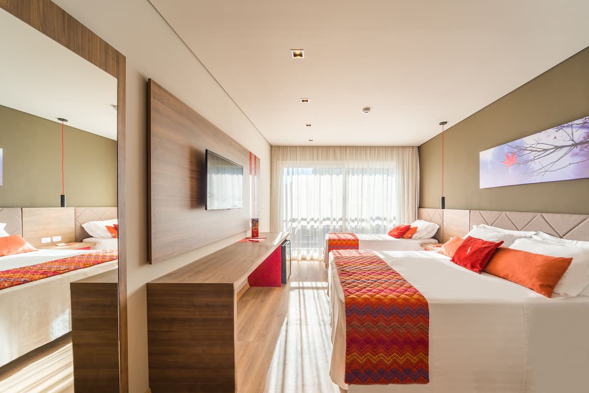 A modern hotel room with two beds, a desk, and a large window.