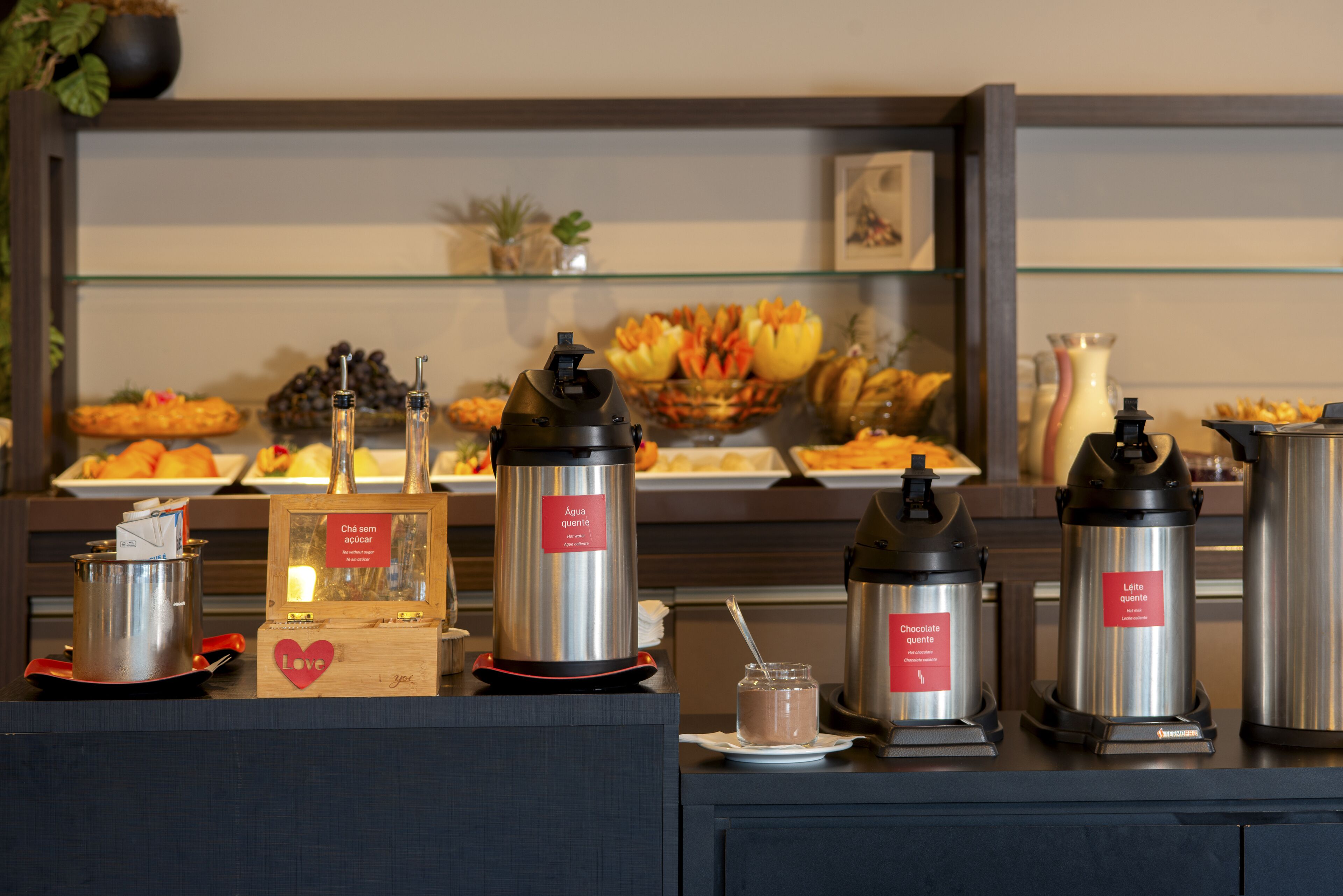 A buffet area with various food items and beverage dispensers labeled with different drink options.