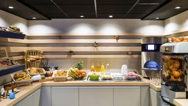 Eine moderne Küche mit Holzböden, einer Kaffeemaschine und verschiedenen Frühstücksangeboten.