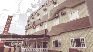 Un hôtel avec une enseigne bien visible portant l’inscription « MARATHON HOTEL » et une plus petite enseigne en dessous indiquant simplement « HÔTEL ».
