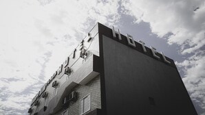 Un hôtel à l’architecture moderne, dont la façade est ornée d’une grande enseigne indiquant « HÔTEL ».