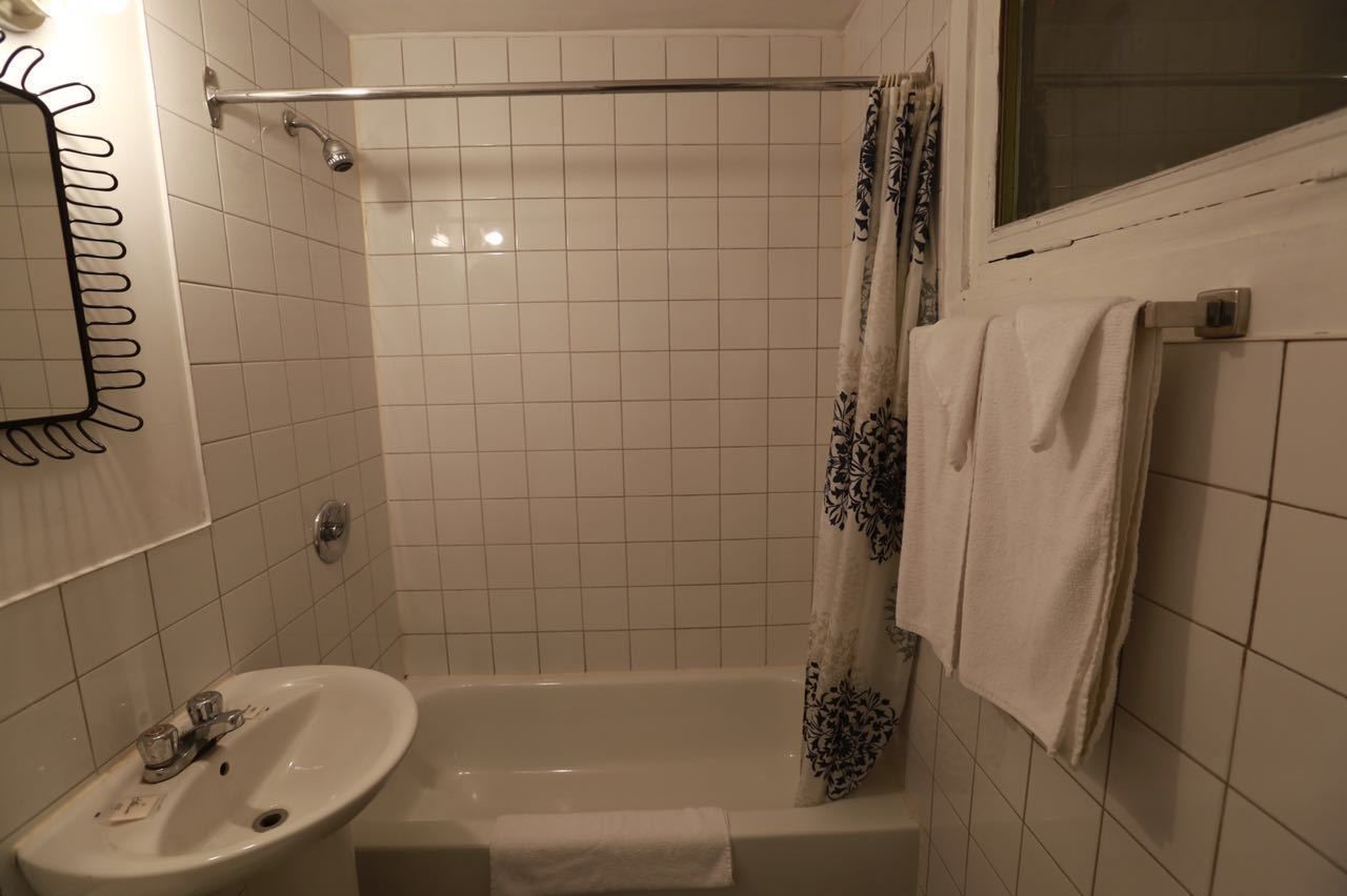 A bathroom with a bathtub, a shower, a sink, and a mirror.