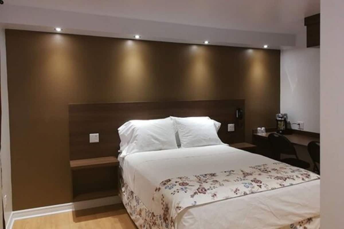 Una habitación de hotel con una cama, un escritorio y una silla.