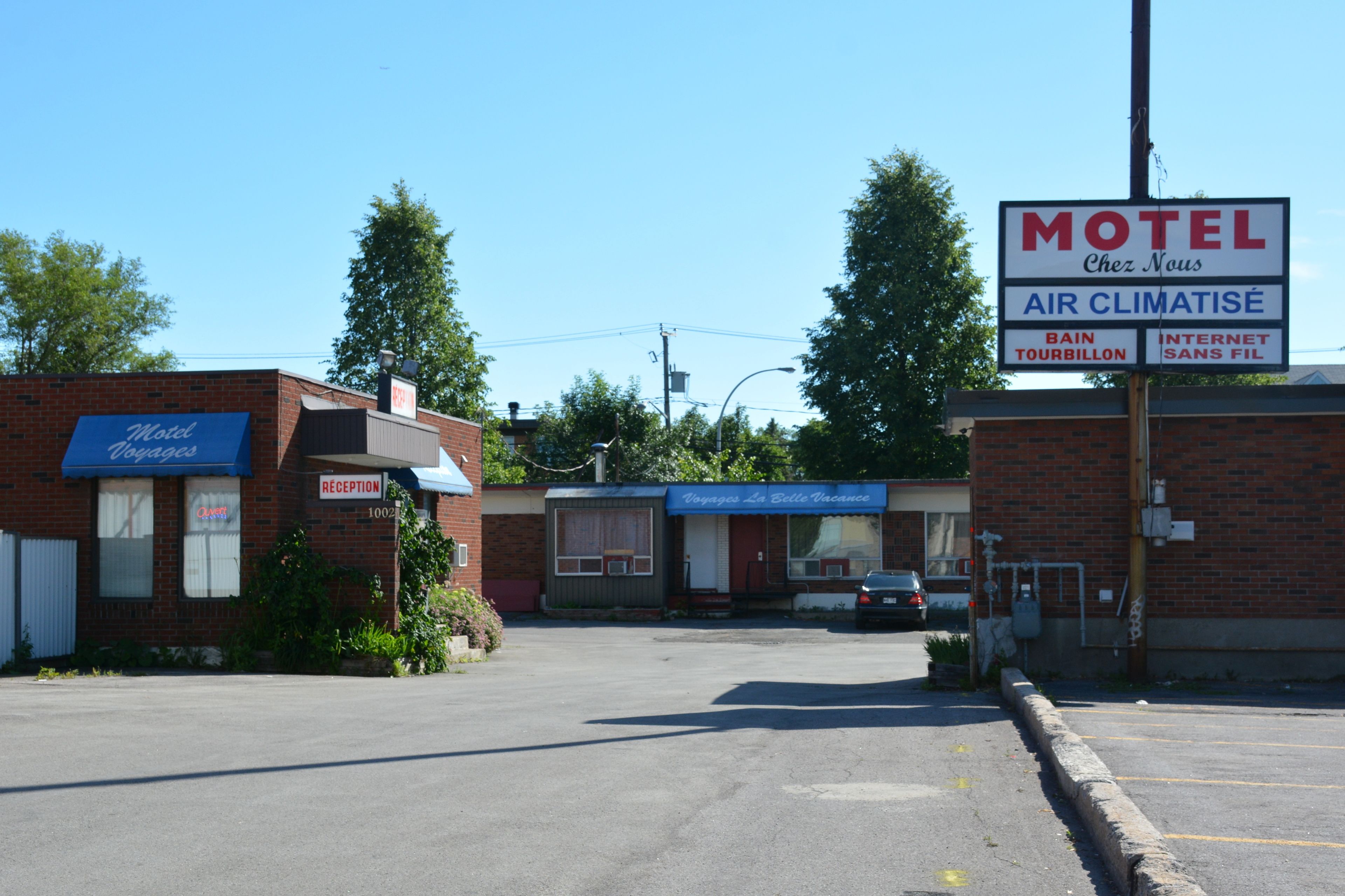 Um motel com área de recepção e sinalização indicando serviços como ar condicionado e internet.