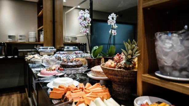 A buffet with various food items, including cakes, fruits, and cheeses.
