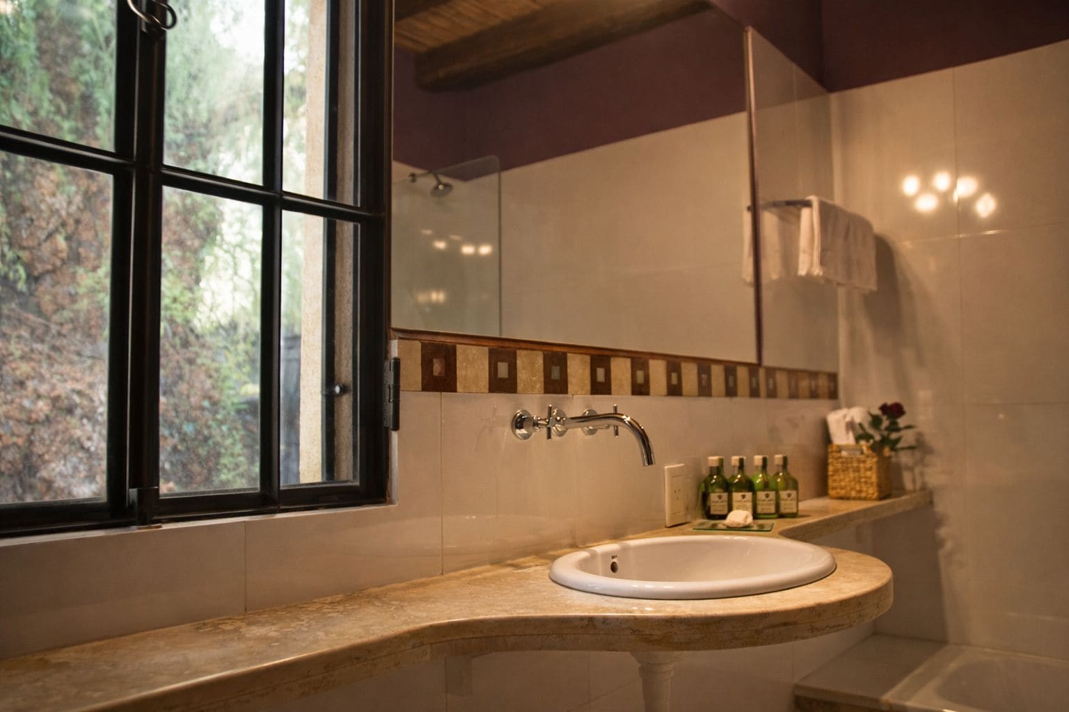 Ein Badezimmer mit Fenster, Waschbecken und Dusche.