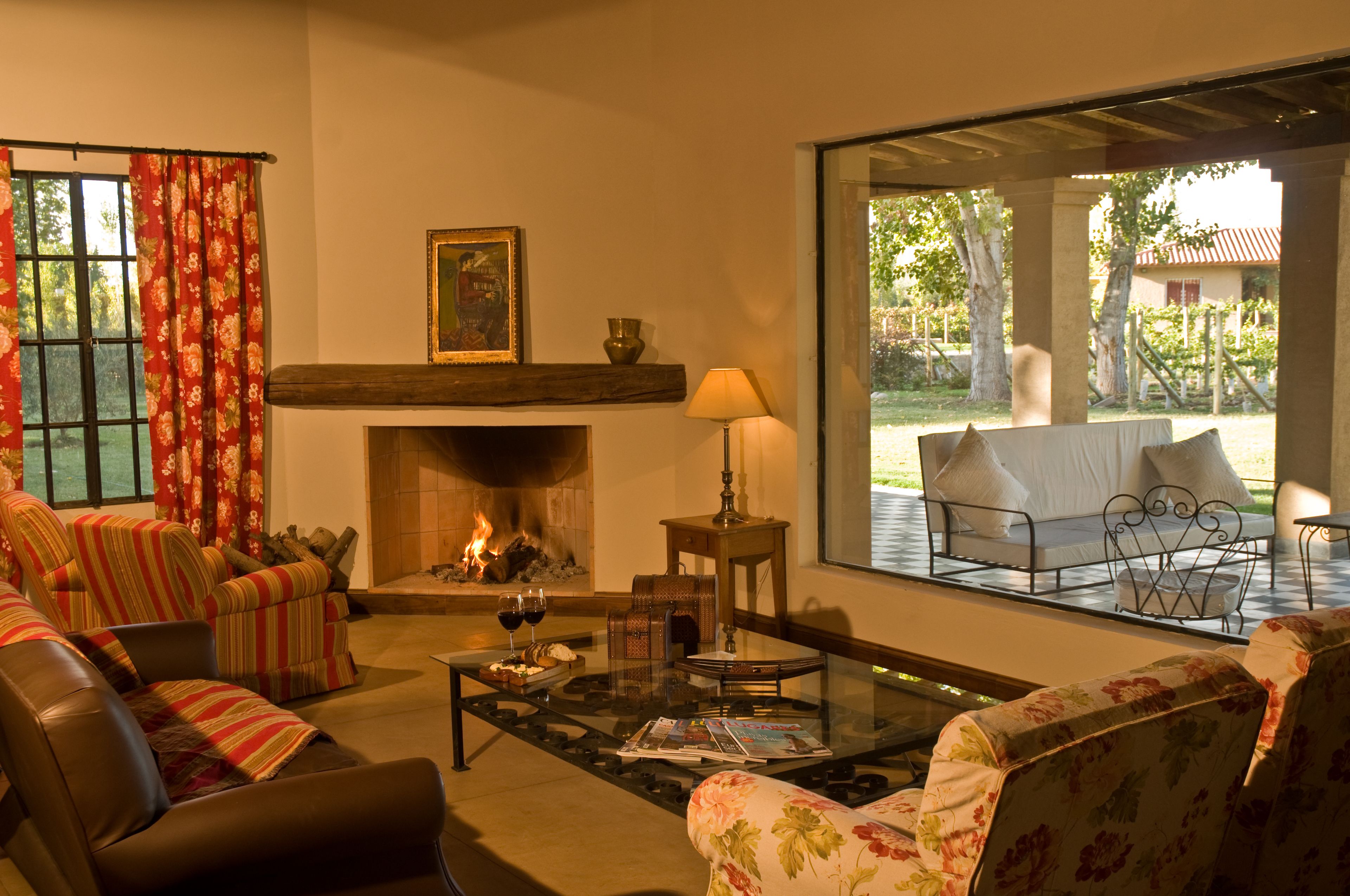 A cozy living room with a fireplace, comfortable seating, and a view of the outdoors.