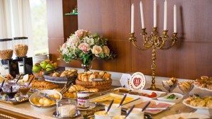 Un bufé con diferentes opciones de comida, un arreglo floral y un candelabro.