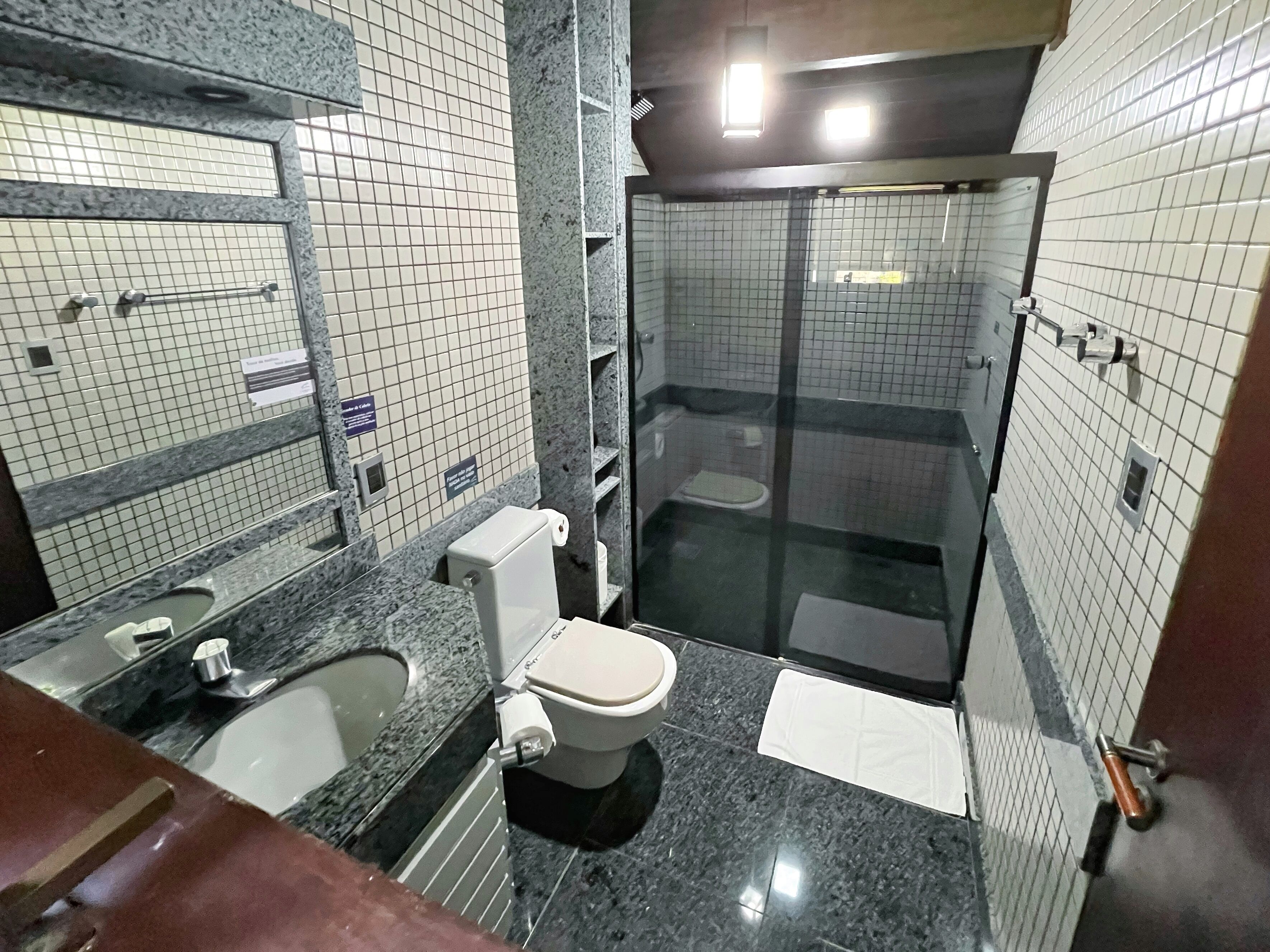 Un baño con inodoro, lavabo y zona de ducha.