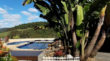 Una piscina al aire libre, sillones reclinables de piscina