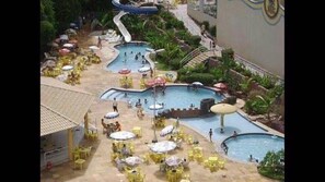 A resort pool area with multiple pools, sun loungers, and umbrellas. - Golden Dolphin Grand Hotel - Apartamento (Caldas Novas)