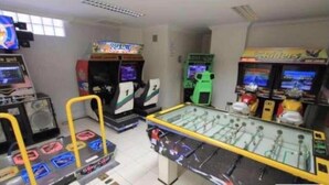 A room with multiple arcade machines, including a foosball table, and a few vending machines. - Golden Dolphin Grand Hotel - Apartamento (Caldas Novas)