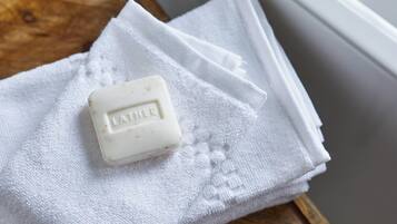 Un pain de savon portant l’inscription « LATHER » sur une serviette blanche.