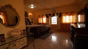 A bedroom with a bed, a dresser, a mirror, and a window with curtains. - Paradise Reggae Resort (Spanish Town)