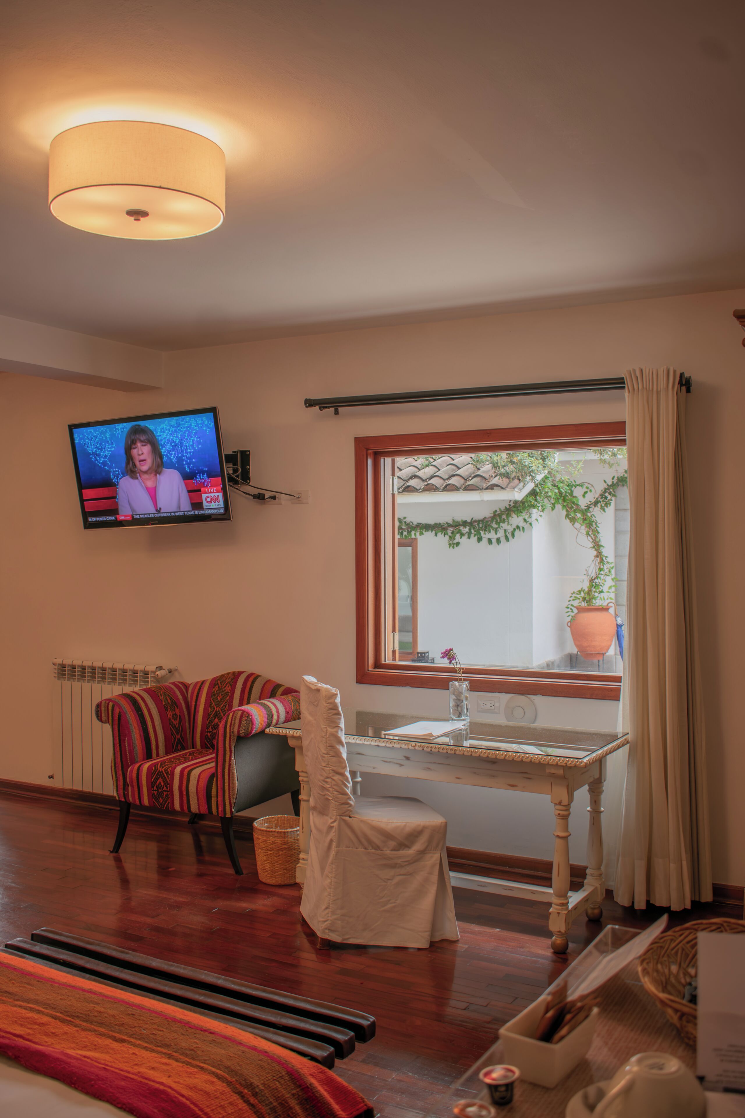 Una sala de estar con televisor, ventana con vistas, sofá y una mesa.