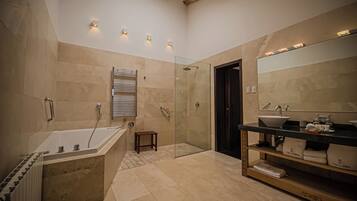 A modern bathroom with a freestanding bathtub, a glass-enclosed shower, and a vanity with a large mirror.