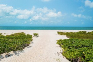 Rannalla, aurinkotuoleja, aurinkovarjoja, rantapyyhkeitä