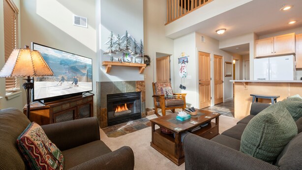 A spacious living room with a fireplace, a television, and a cozy seating area.