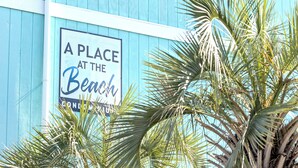 A sign on a building with palm trees in the foreground. - Beautiful Top Floor Oceanfront Condo, Breathtaking Views from
Oceanfront Balcony (Carolina Beach)