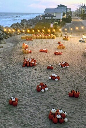 Een strand met hooi balen en pompoenen, geordend in een patroon.