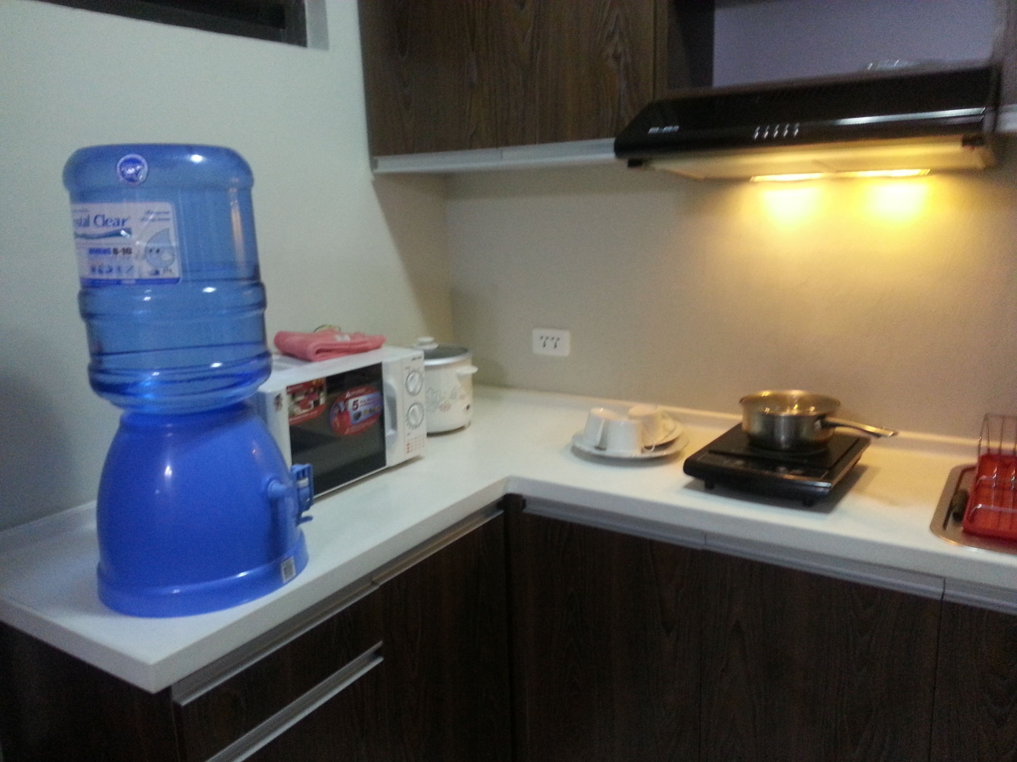 Una cocina equipada con microondas, tostadora y dispensador de agua.