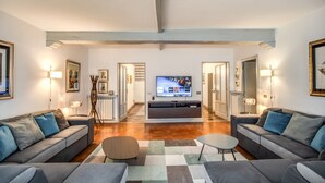 Una sala de estar moderna con un televisor de pantalla plana grande, sofás grises y una mesa de centro.