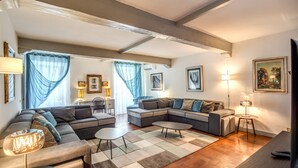 Una sala de estar moderna con un sofá modular, una mesa de centro y un televisor.