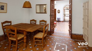A dining area with a wooden table and chairs, a hanging light fixture, and a tiled floor. - 4 bedrooms, free parking. Santa Cruz quarter (Sevilla)