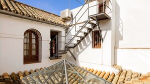 A building with a glass atrium, a staircase, and a tiled roof. - 4 bedrooms, free parking. Santa Cruz quarter (Sevilla)