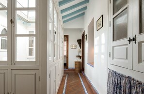 A hallway with white doors, a patterned floor, and a blue ceiling. - 4 bedrooms, free parking. Santa Cruz quarter (Sevilla)