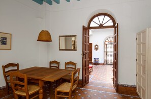 A dining area with a wooden table and chairs, a hanging light fixture, and a tiled floor. - 4 bedrooms, free parking. Santa Cruz quarter (Sevilla)