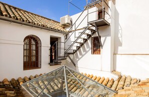 A building with a glass atrium, a staircase, and a tiled roof. - 4 bedrooms, free parking. Santa Cruz quarter (Sevilla)