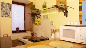 A kitchen with a microwave, wooden counter, and various kitchen items. - Catania City Center: A Little Gem in the Historic Center of Catania (Catania)