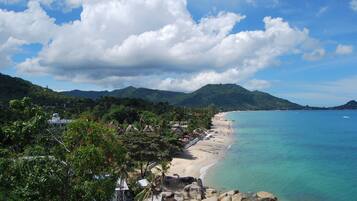 Una playa cerca, sillas reclinables de playa, toallas de playa