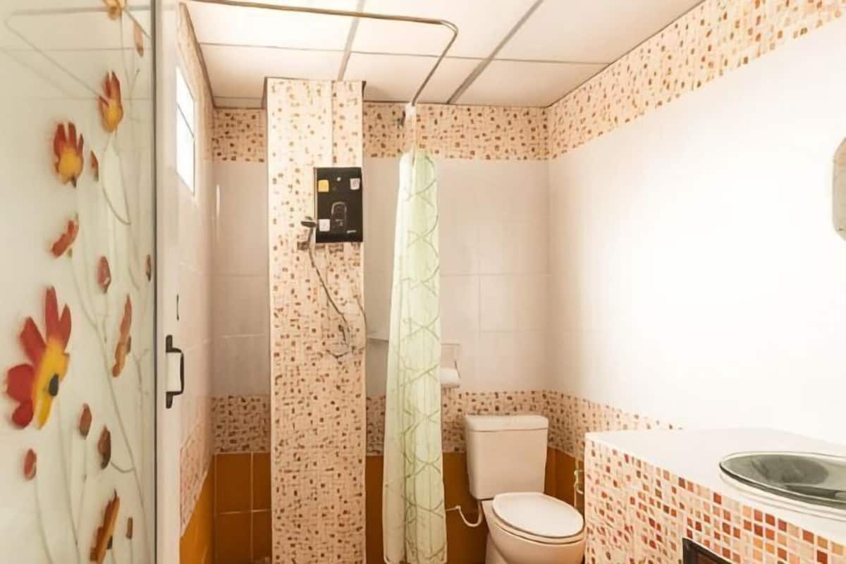 Ein Badezimmer mit Dusche, Toilette und Waschbecken.
