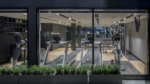A modern gym with treadmills, weight machines, and dumbbells.
