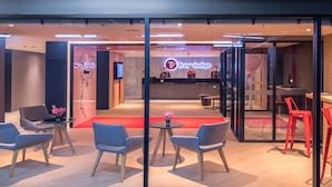 A modern reception area with a Travelodge sign, a reception desk, and seating arrangements.
