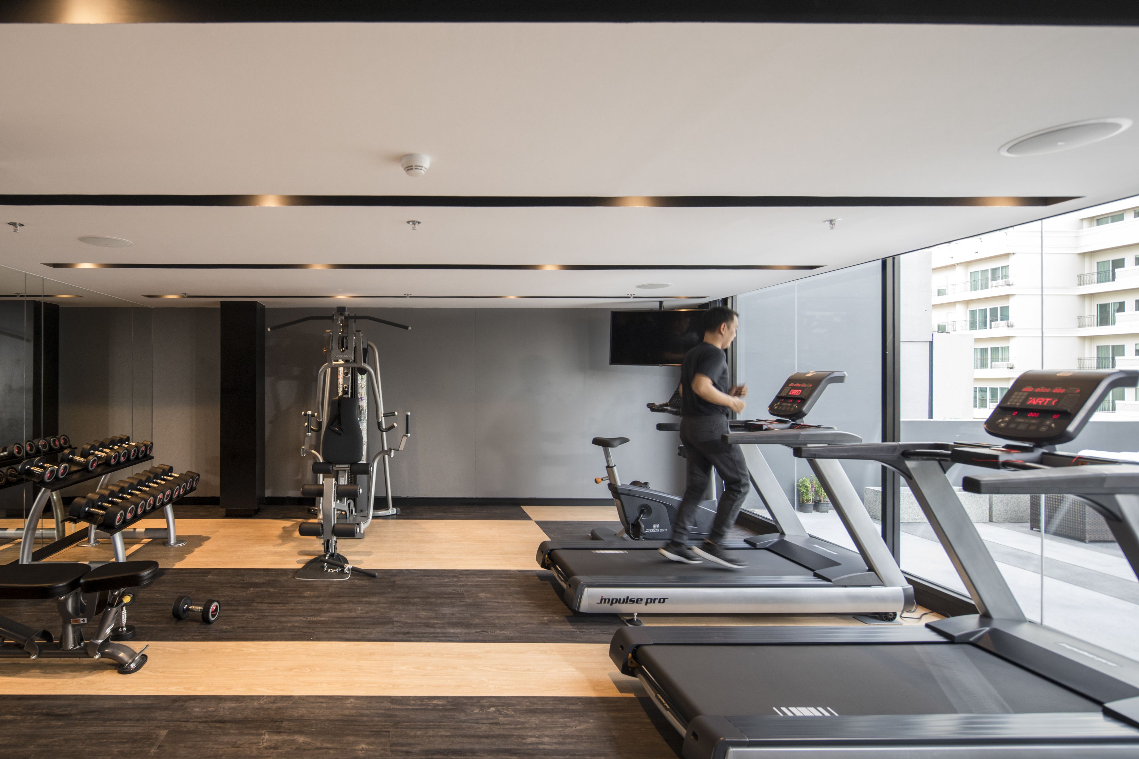 Una palestra moderna con tapis roulant, manubri e macchinari per l'allenamento con i pesi.