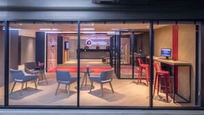 A modern reception area with a Travelodge sign, seating arrangements, and a reception desk.