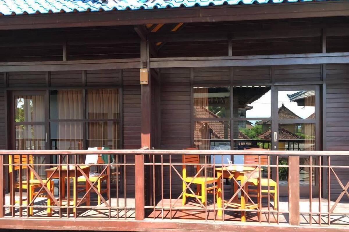 Un bâtiment en bois doté d’un balcon et de nombreuses fenêtres.