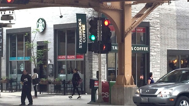 A street scene with a Starbucks Coffee shop, a Creative Framing store, and a CS Coffee shop.