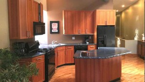 A modern kitchen with wooden cabinets, a central island, and a built-in stove. - Affordable Month to Month In The Heart Of Chicago. 30 Day Minimum Bookings. (Chicago)