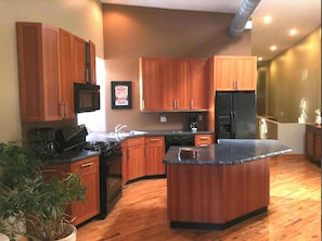 Enjoy cooking in this well-equipped kitchen with a central island, appliances, and ample storage.